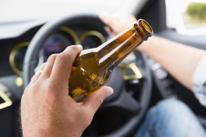 Man drinking beer while driving